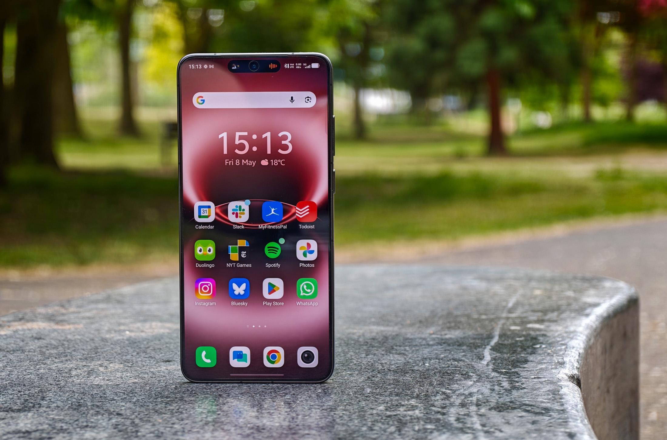 Photo of the Vivo X300 Ultra standing on a gray stone bench showing the homescreen.