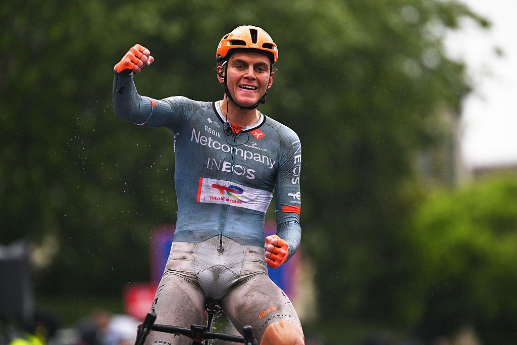 Shmidt covered in dirt from rain celebrates with one arm raised