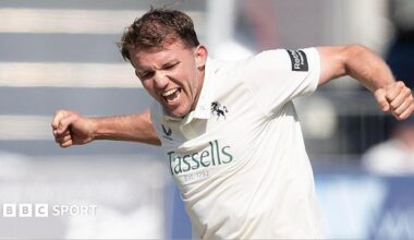 Matt Milnes in a white cricket shirt does a fist pump