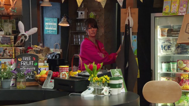 Kerry Wyatt standing in the shop in Emmerdale.
