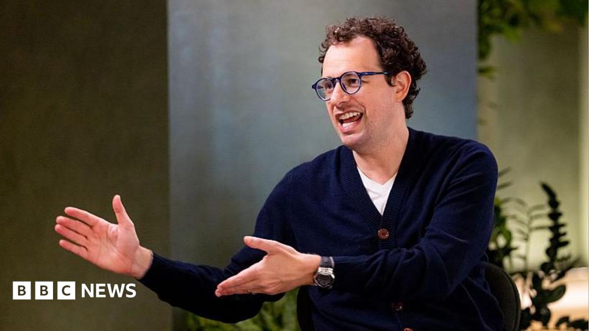 Dario Amodei, co-founder and chief executive officer of Anthropic, speaking during an interview in a room decorated with plants