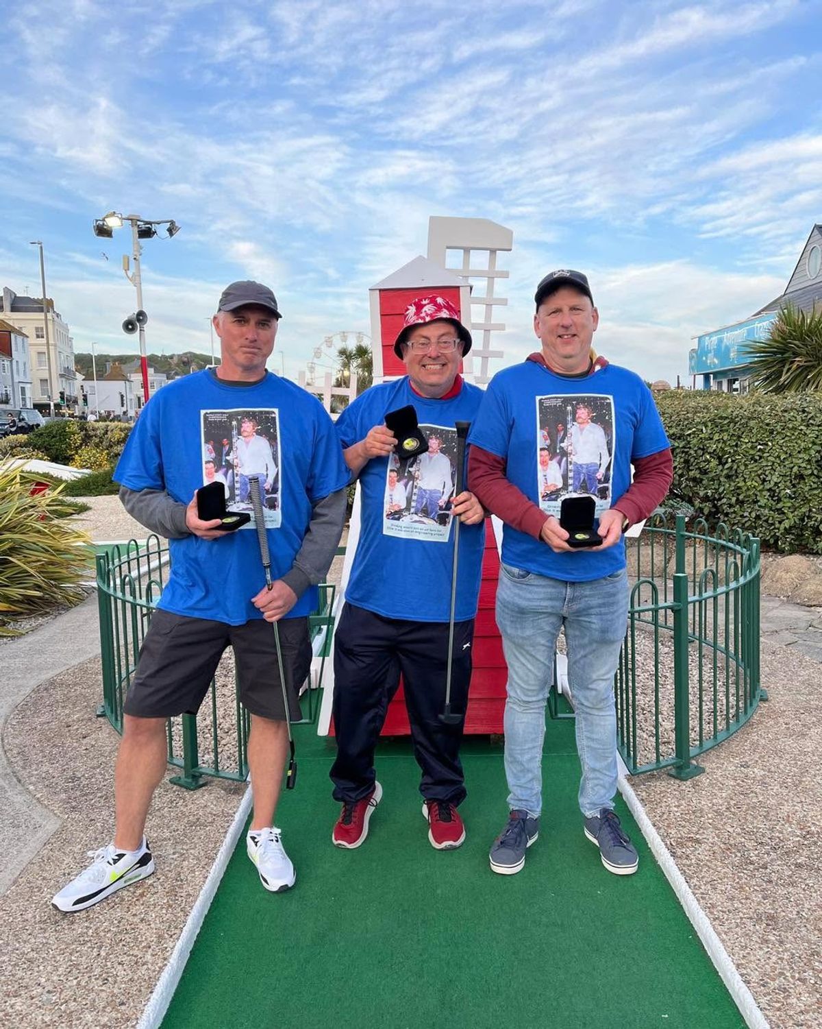 The Oliver Reed Temperance Society, Wellingborough’s Rob Webb, Beverley's Mark Stillman and Tonbridge’s Brad Ames, with their silverware posing in front of The Windmill crazy golf hole.