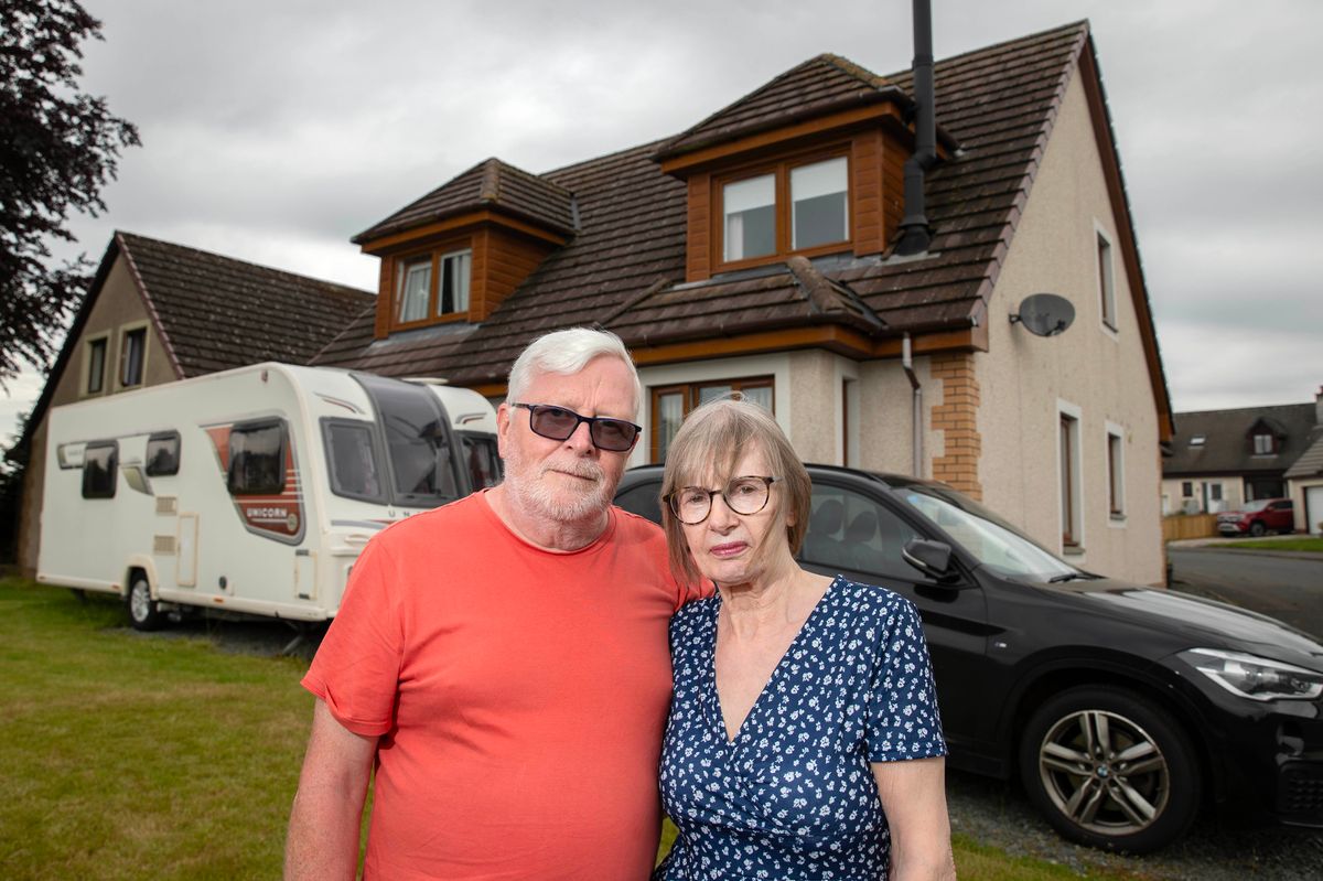 elderly couple outside house