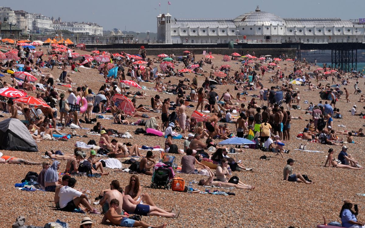 People crowd the beach to enjoy the sunshine in Brighton
