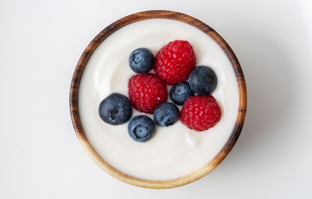 Berry yogurt in a bowl and fresh blueberry, raspberry