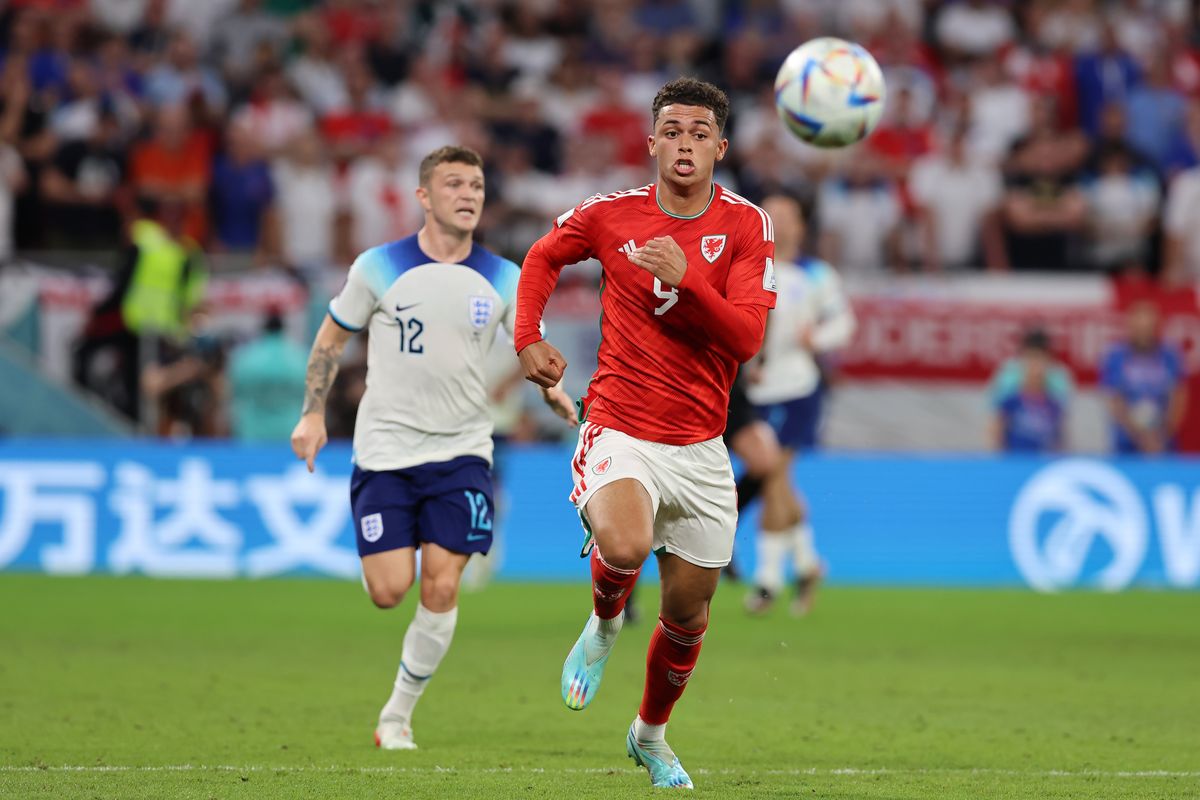 Brennan Johnson of Wales chases after the ball as he is pursued by Kieran Trippier of England during the FIFA World Cup Qatar 2022 Group B match between Wales and England at Ahmad Bin Ali Stadium