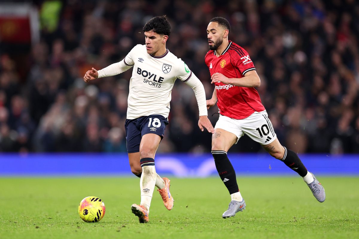 Mateus Fernandes of West Ham United breaks away from Matheus Cunha of Manchester United during the Premier League match between Manchester United and West Ham United at Old Trafford on December 04, 2025 in Manchester, England.