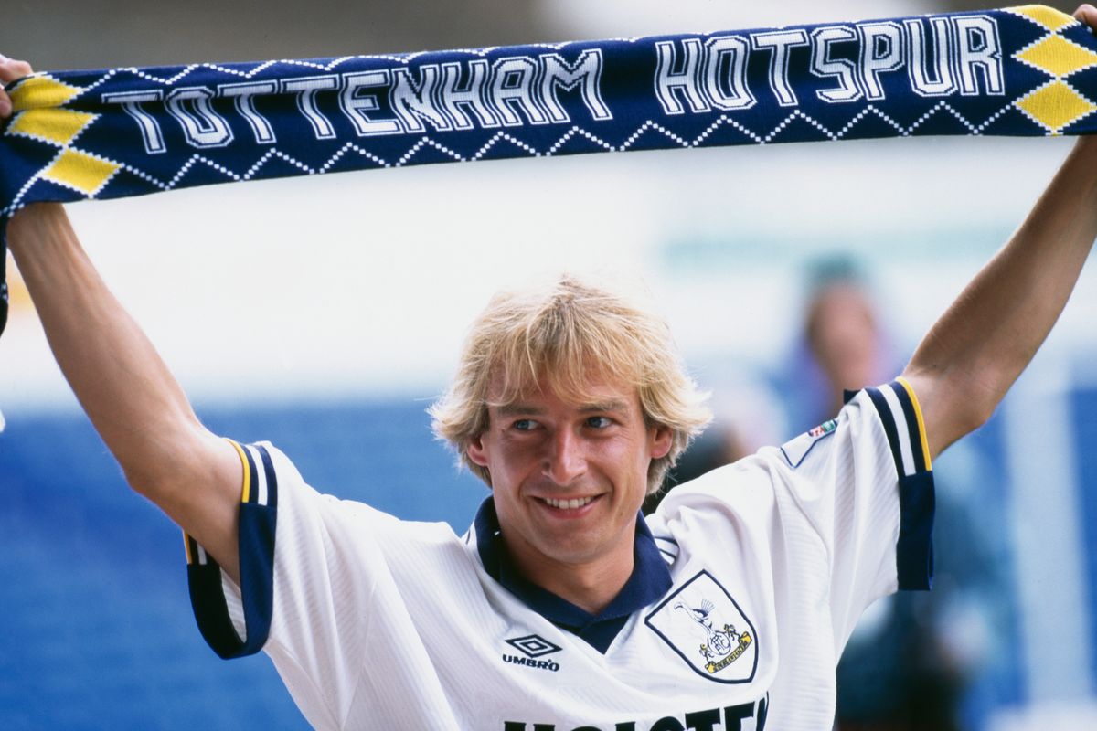 German footballer Jürgen Klinsmann holds up a Tottenham Hotspur scarf after signing with the club