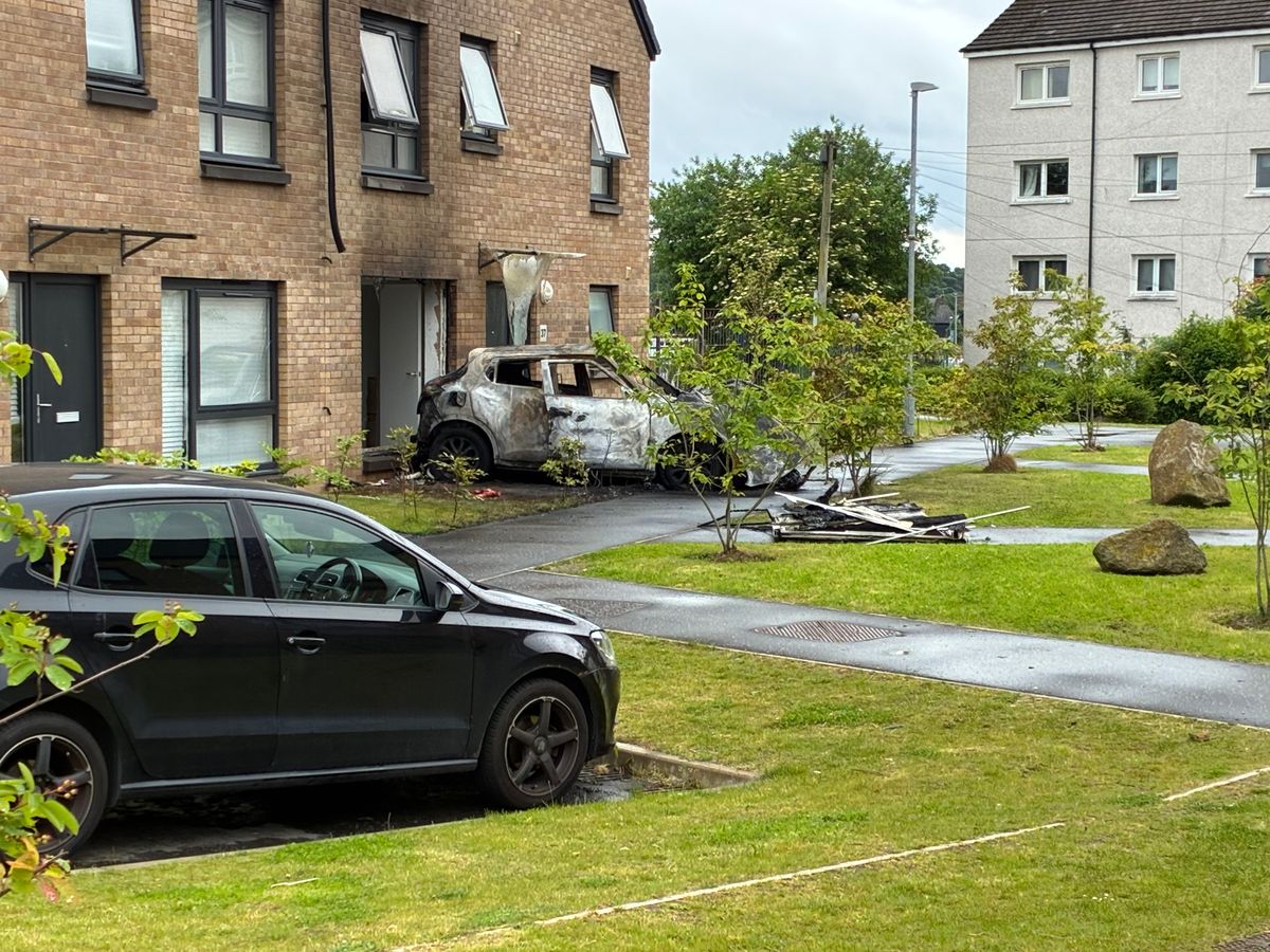 Debris lies in front of the burnt out vehicle.