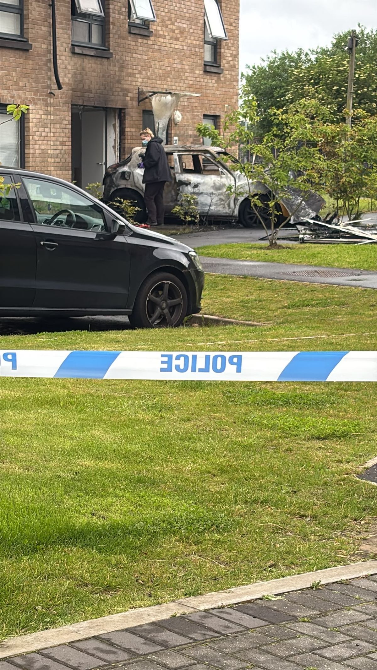 A detective beside the vehicle used to ram the house.