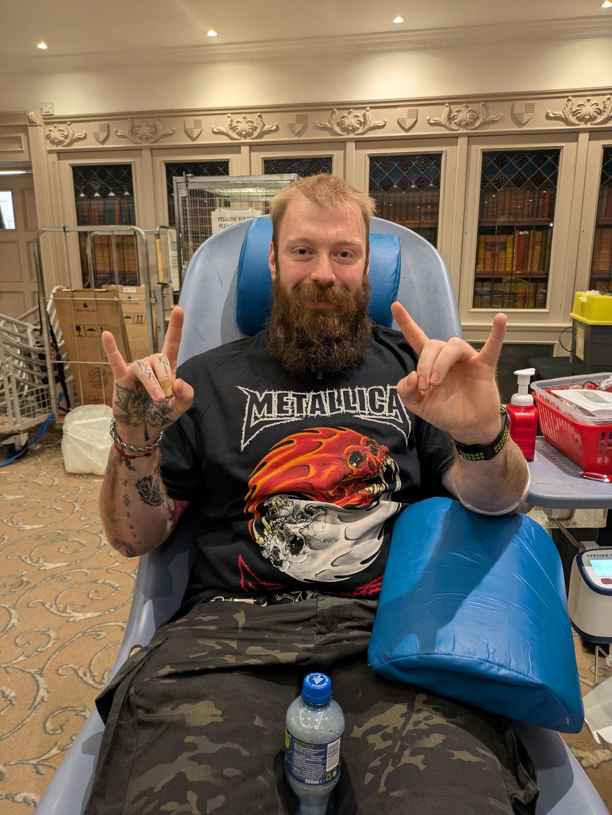 A man in a Metallica tshirt giving blood