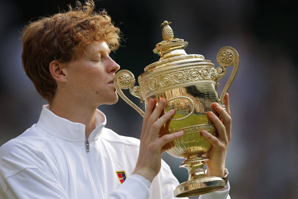 Jannik Sinner kisses the Wimbledon trophy