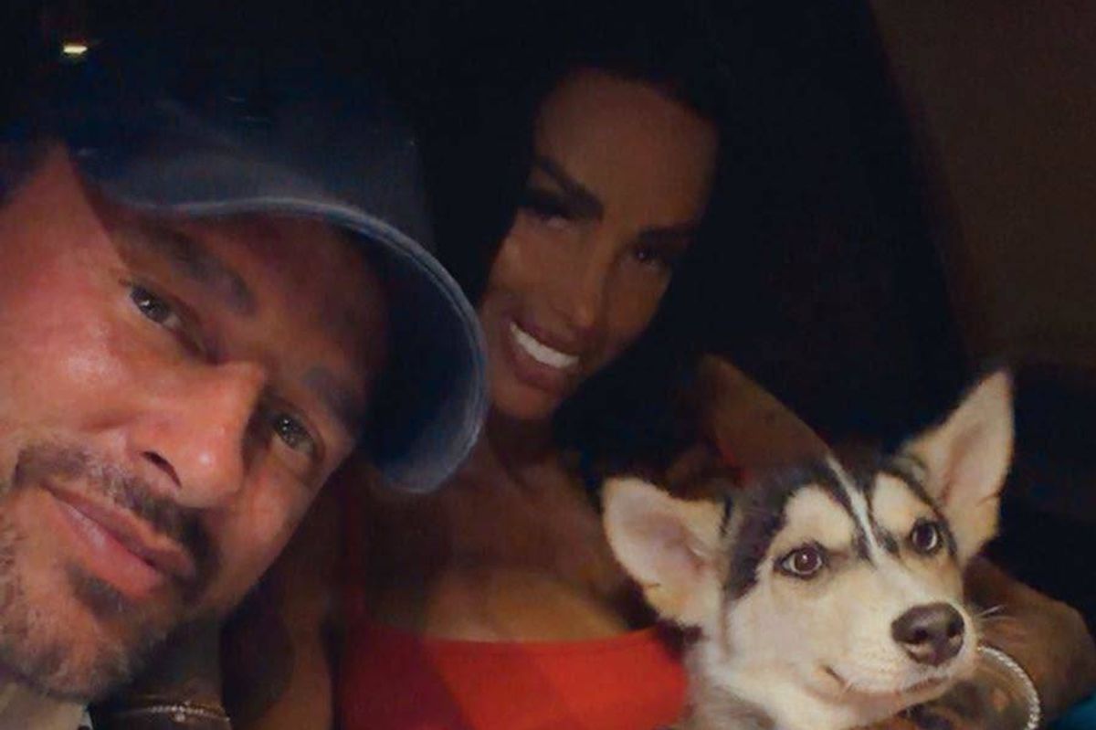 An image showing two individuals with a Siberian Husky dog, all appearing to be in a cheerful and intimate moment, with the dog in the foreground.
