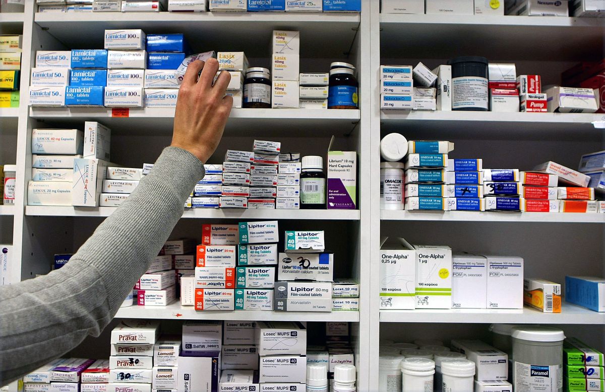a pharmacist stocking shelves at a chemist