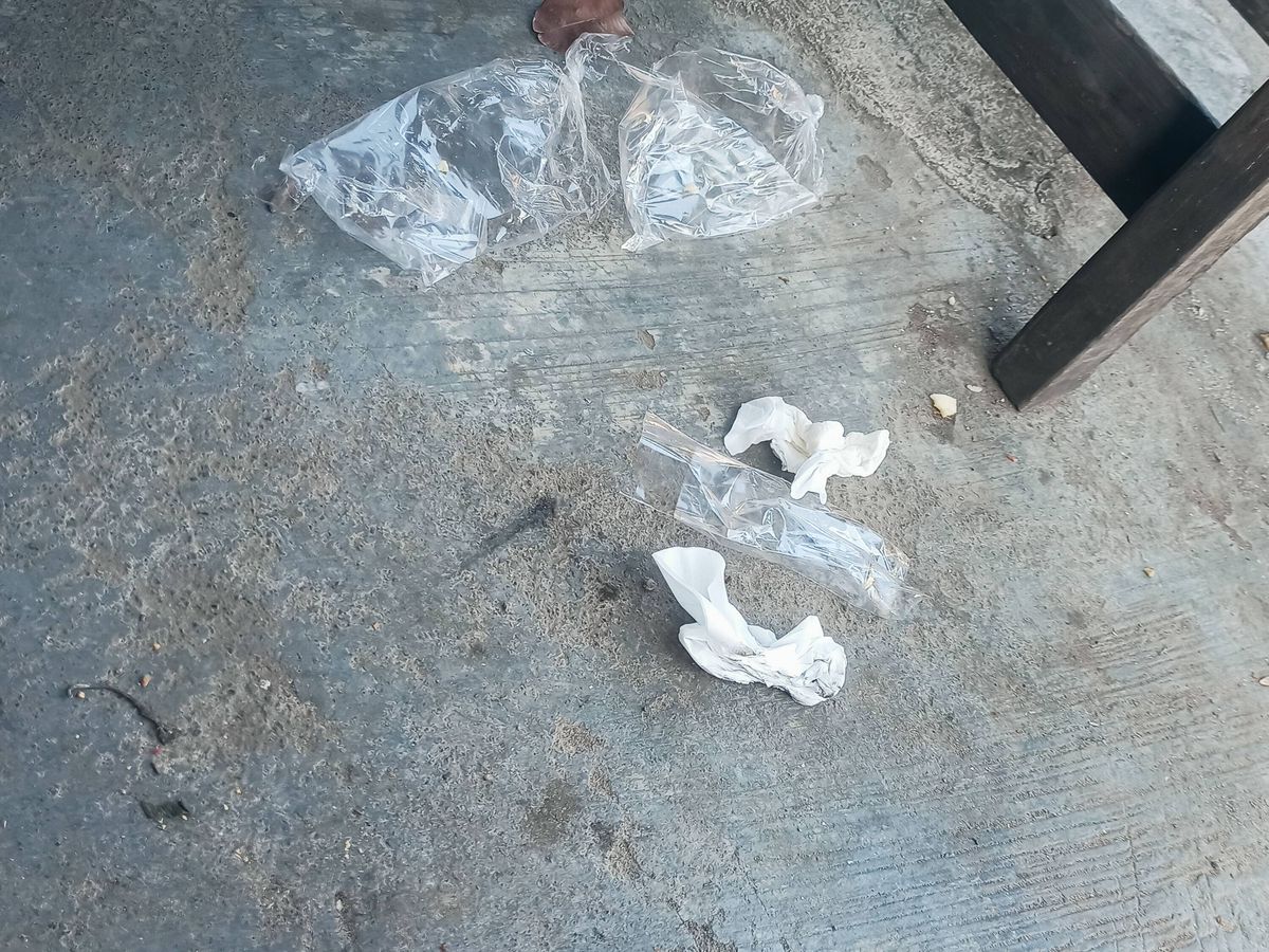 Plastic wrappers and tissue papers are scattered on the floor, creating a messy environment.