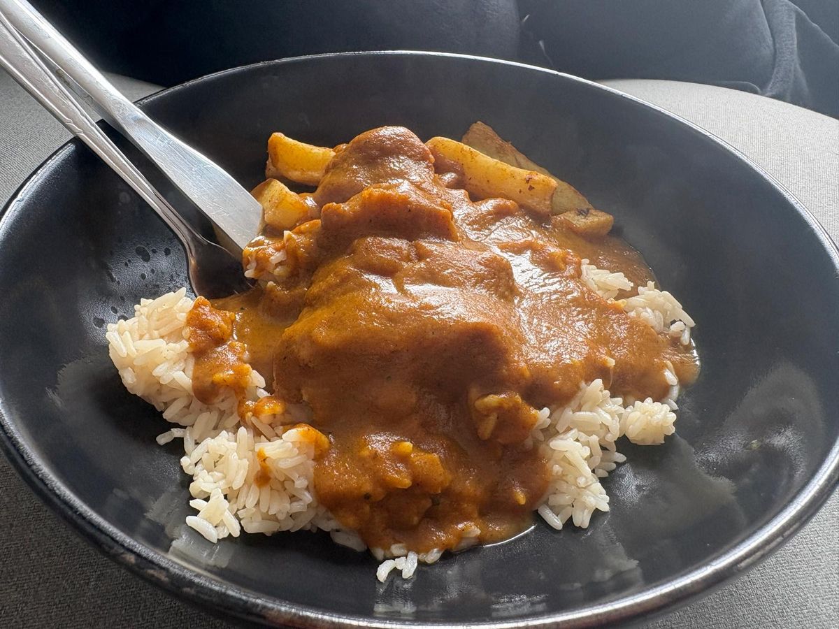 A fish katsu curry made from onion, carrot, mild curry powder, turmeric, plain flour, chicken stock, milk, basmati rice, a Birdseye fish fillet and Aunt Bessie's skin on fries
