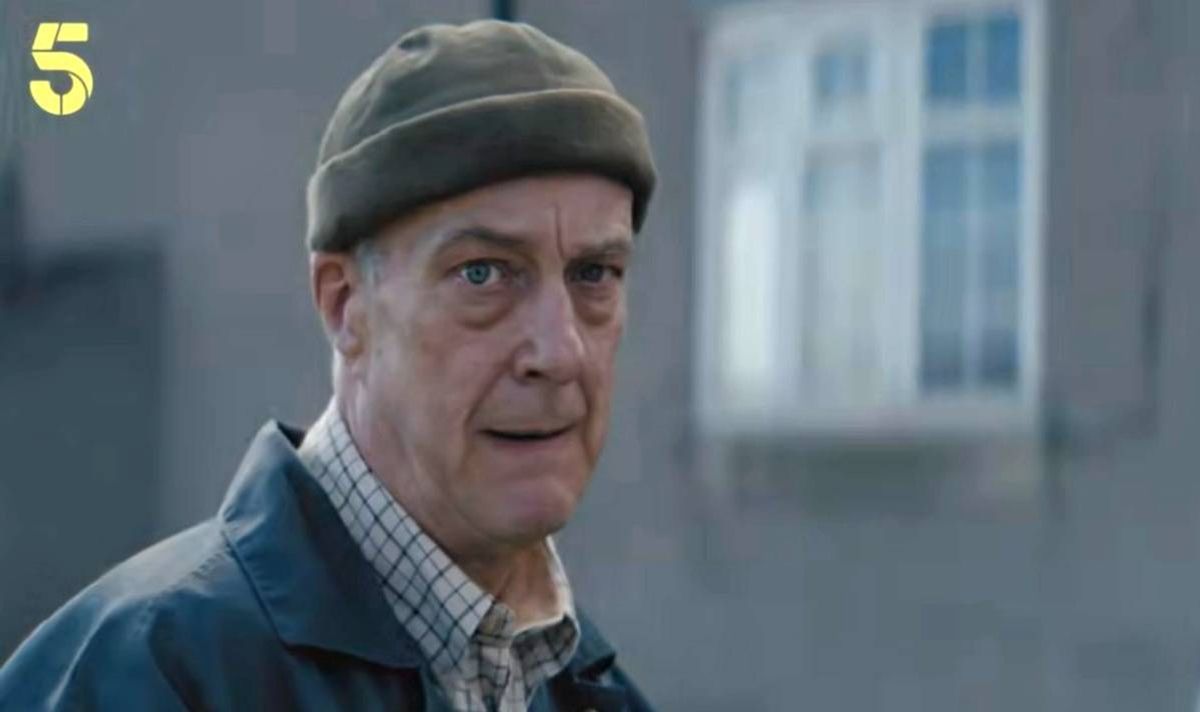 Clean shaven man in blue jacket and green beanie hat