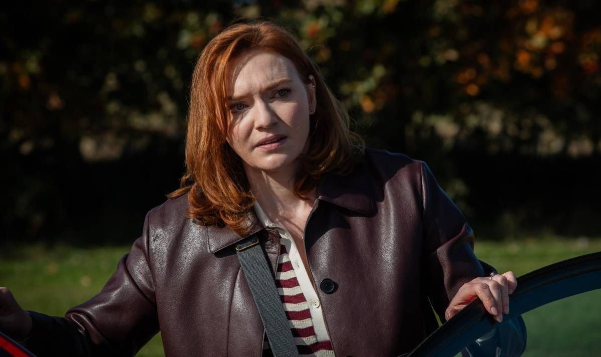 Red headed woman wearing brown leather jacket