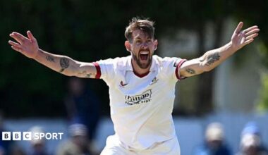 Playing in a Championship game, Tom Bailey has both arms outstretched appealing for a wicket towards the umpire