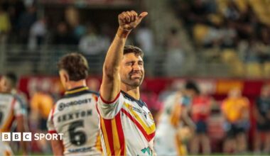 Catalans Dragons winger Tommy Makinson celebrating by raising his right thumb up and winking towards the crowd.