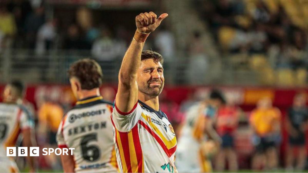 Catalans Dragons winger Tommy Makinson celebrating by raising his right thumb up and winking towards the crowd.