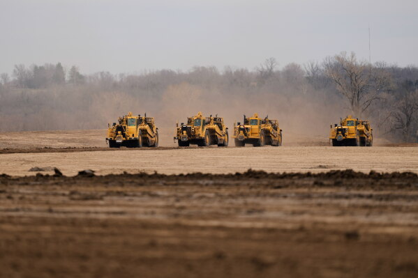 Earth movers prepare a site for a 2.5 million square foot AI data center March 24, 2026, in Independence, Mo. (AP Photo/Charlie Riedel, File)