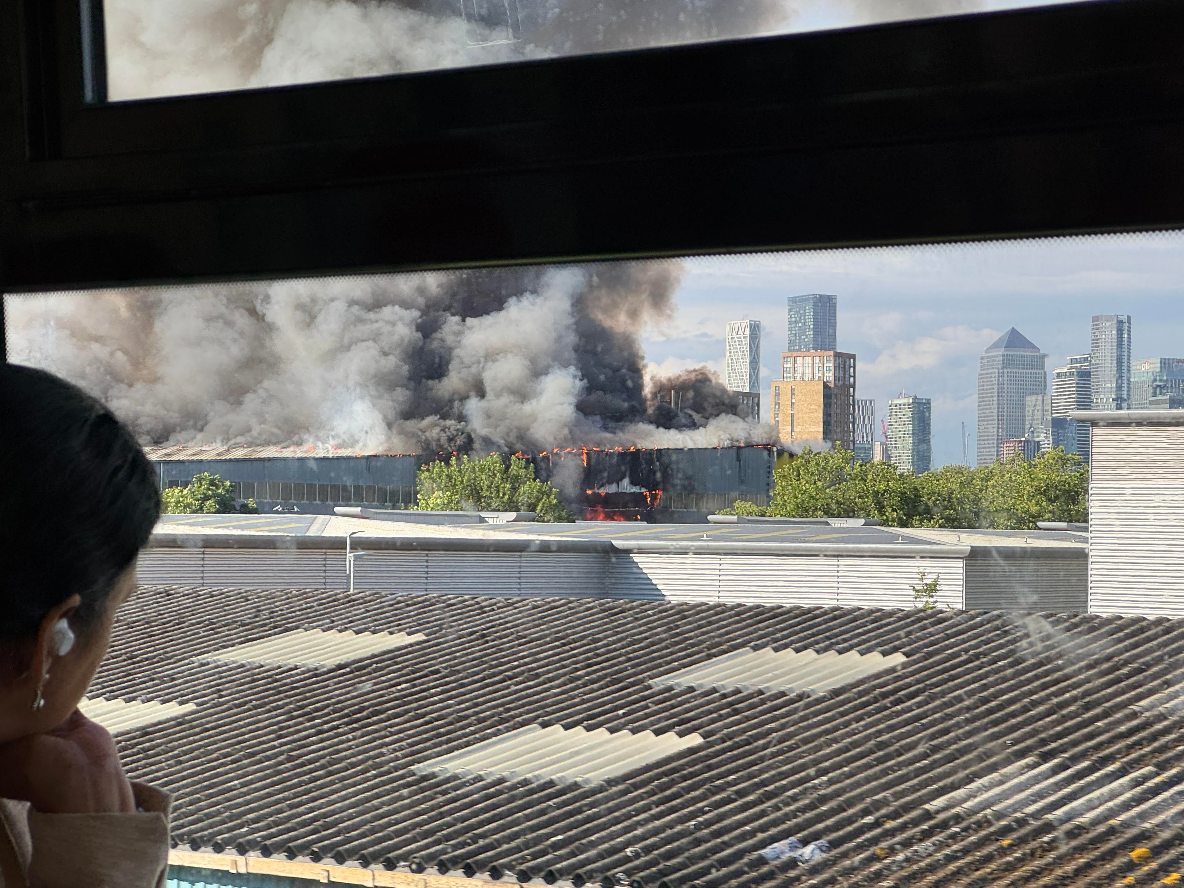 Smoke and flames from the site of a major fire in London, as seen from a train from London Bridge