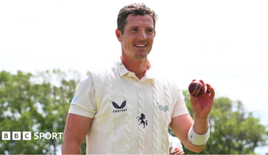 Keith Dudgeon, wearing Kent whites, holds up the ball at the end of the Lancashire innings to celebrate taking six wickets