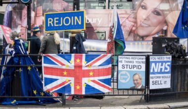 Signs and a hybrid UK-EU flag on a fence at the Parliament Square in London during a 2025 protest by British pro-EU activists urging the country to rejoin the European Union.