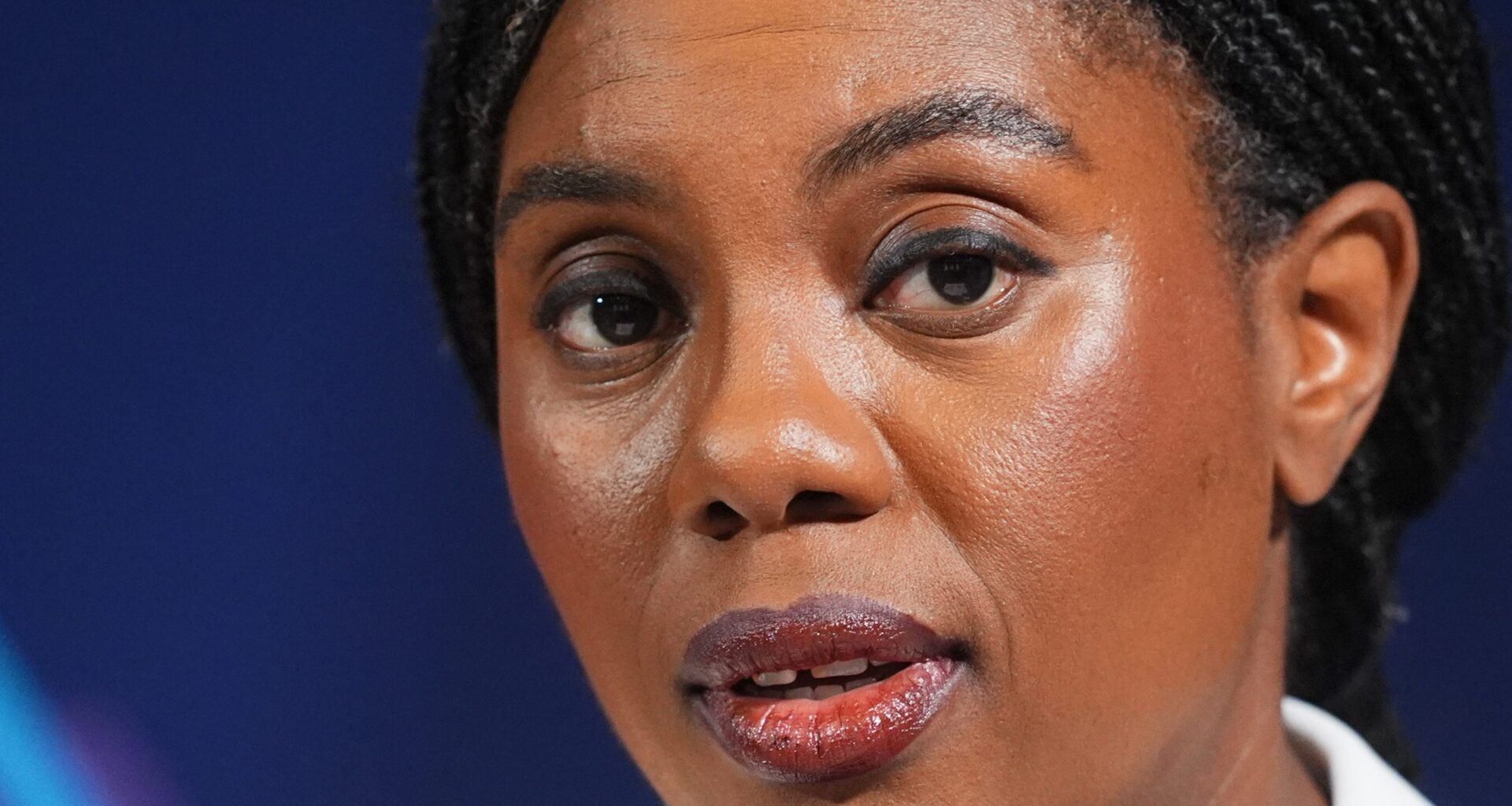 Kemi Badenoch speaking at a podium during a press conference, addressing recent policy changes and business initiatives.