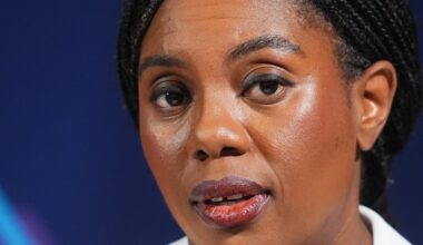 Kemi Badenoch speaking at a podium during a press conference, addressing recent policy changes and business initiatives.