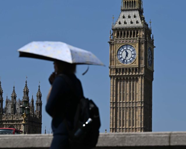 LONDON, UNITED KINGDOM - JUNE 22: People use umbrellas as hot weather continues in London, United Kingdom, on June 22, 2026. The UK Met Office has issued a rare red weather warning for parts of England and Wales ahead of an expected heatwave later this week. (Photo by Rasid Necati Aslim/Anadolu via Getty Images)