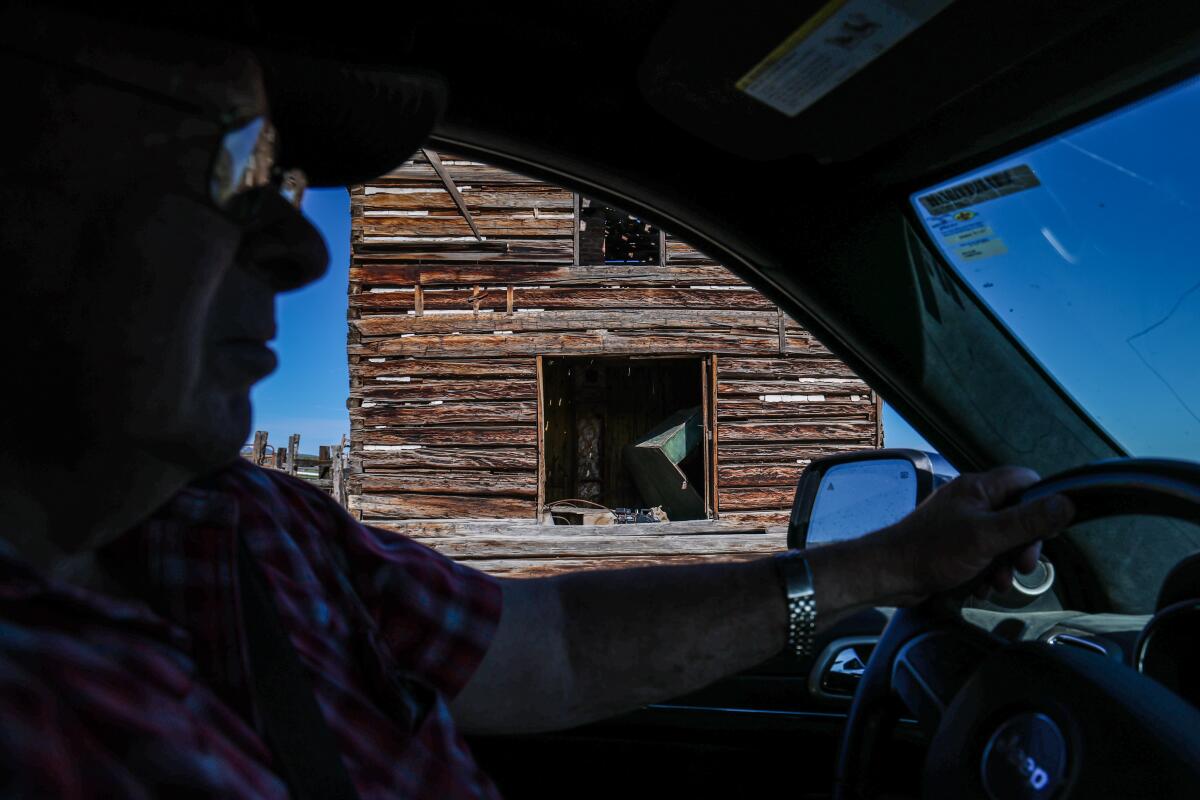 A man driving past an old home
