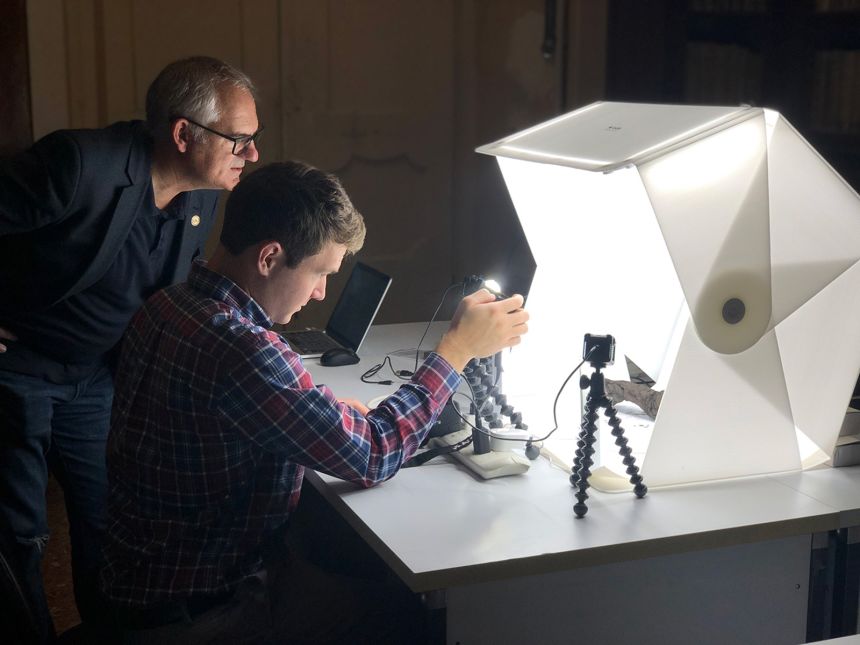 Members of the Vesuvius Challenge team scan a Herculaneum scroll inside its scanning case.