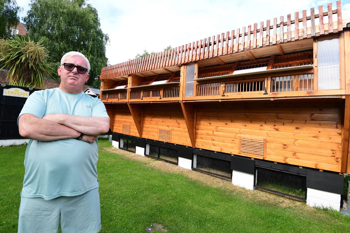 John McKenzie in front of his pigeon loft