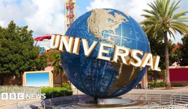 A view of the Universal globe outside the entrance to the Florida park. A roller-coaster and other rides can be seen in the background.