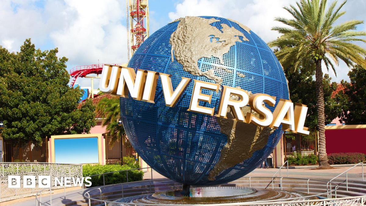 A view of the Universal globe outside the entrance to the Florida park. A roller-coaster and other rides can be seen in the background.