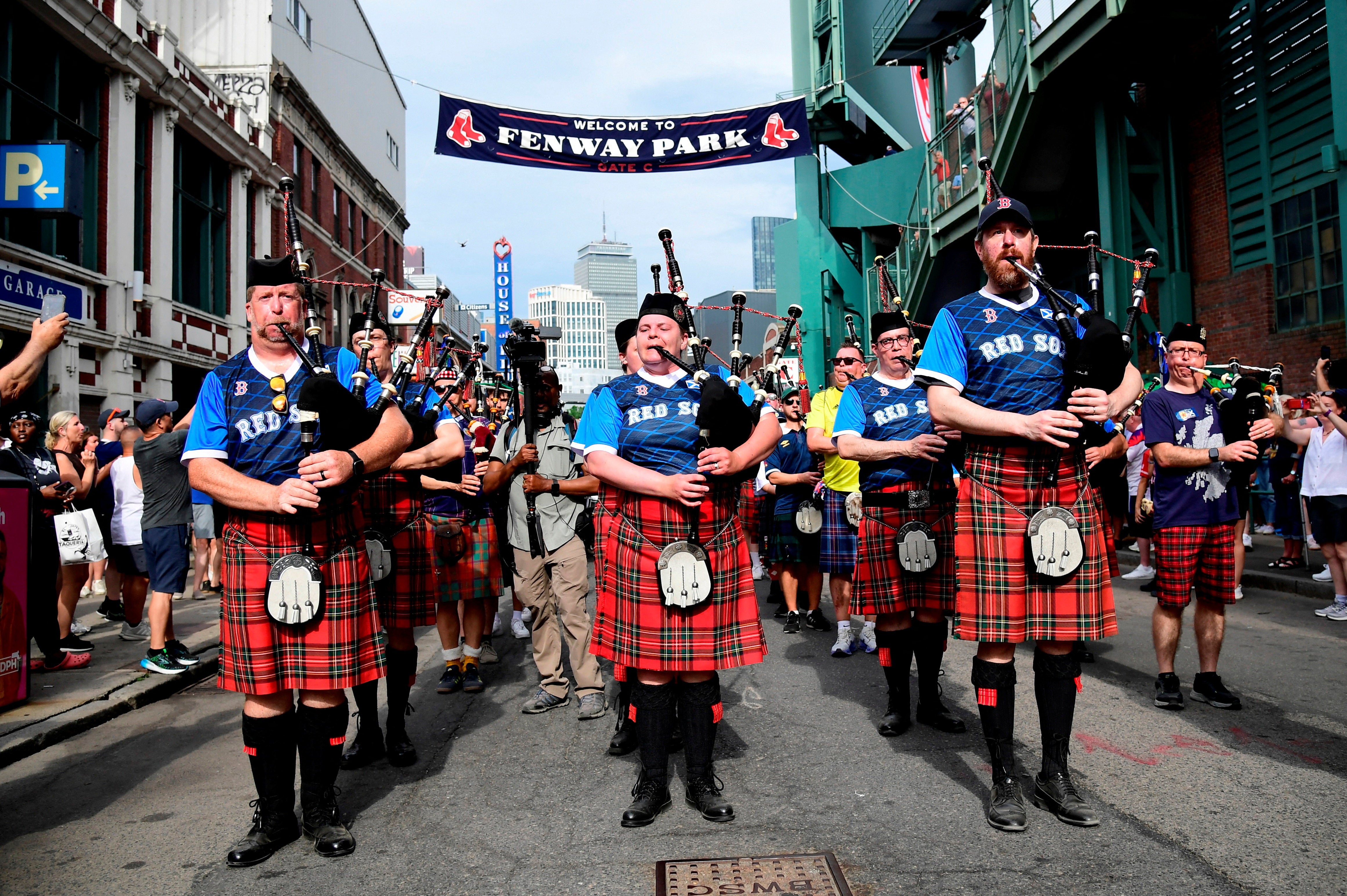 Scotland fans wearing kilts and playing the bagpipes during the march to Fenway Park
