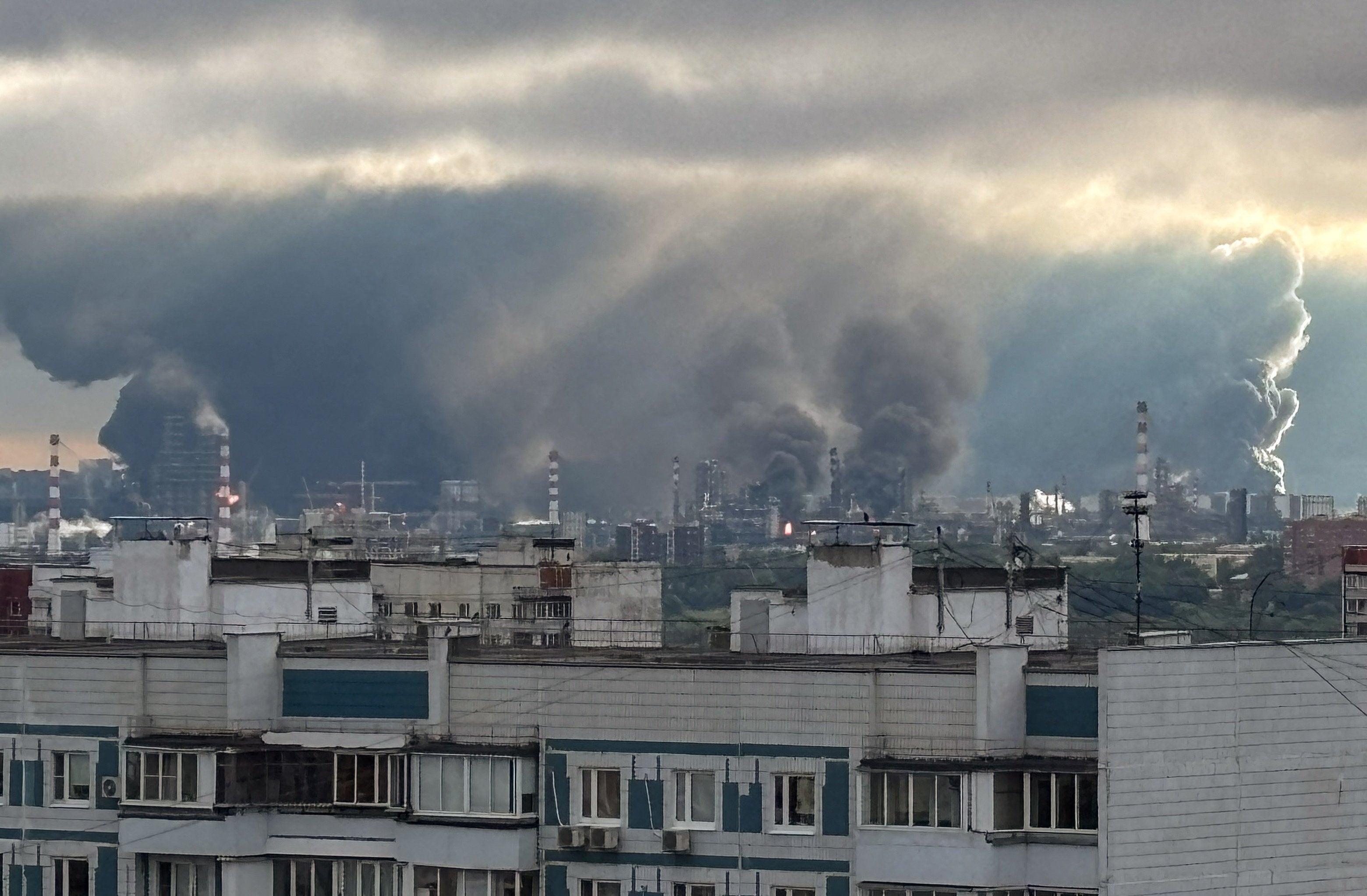 Thick plumes of smoke with flames rise from an oil refinery following what the authorities say is a Ukrainian drone strike in Moscow