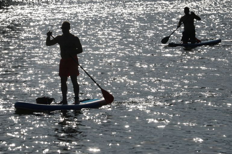 People ride paddle boards along the River Thames as Britain experiences record temperatures that disrupt schools and transport networks, at Richmond, London, Britain, June 25, 2026. REUTERS/Toby Melville TPX IMAGES OF THE DAY