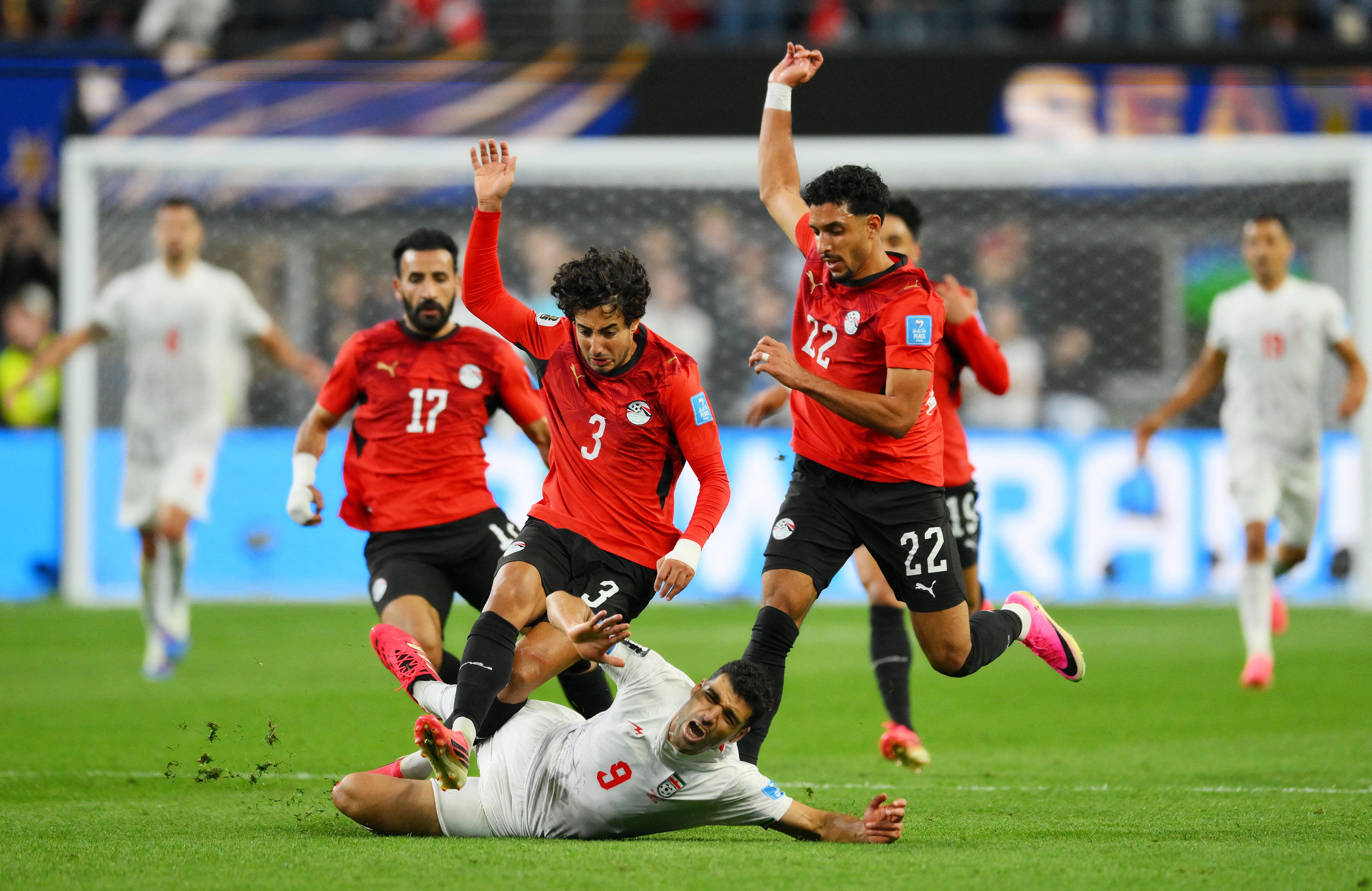 Iran's Mehdi Taremi in action with Egypt's Mohamed Hany and Omar Marmoush