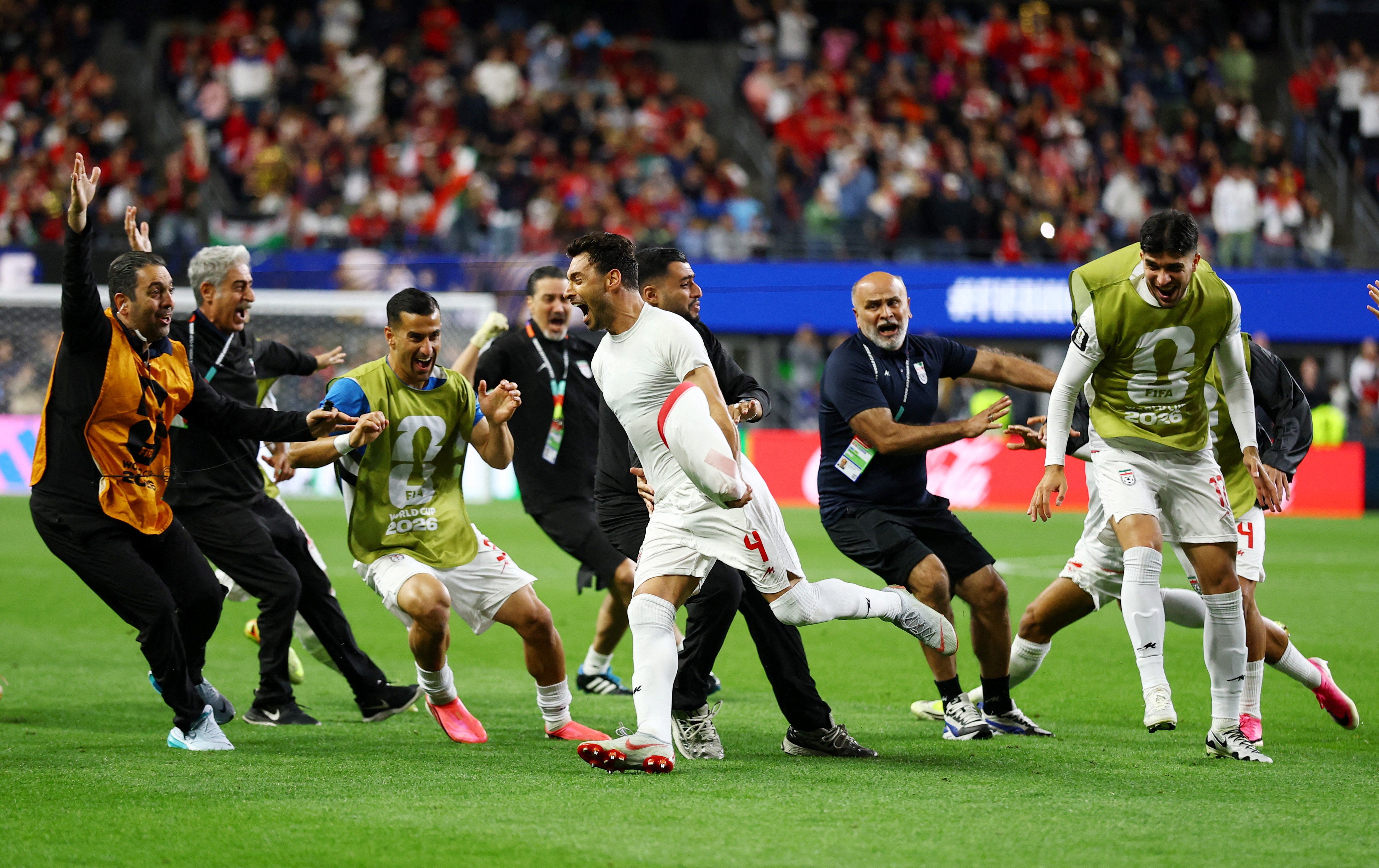 Iran's Shoja Khalilzadeh celebrates scoring a goal with teammates that was later disallowed