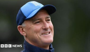 Graham Thorpe wearing a blue baseball cap and blue training top, pictured outdoors with a blurred green background.