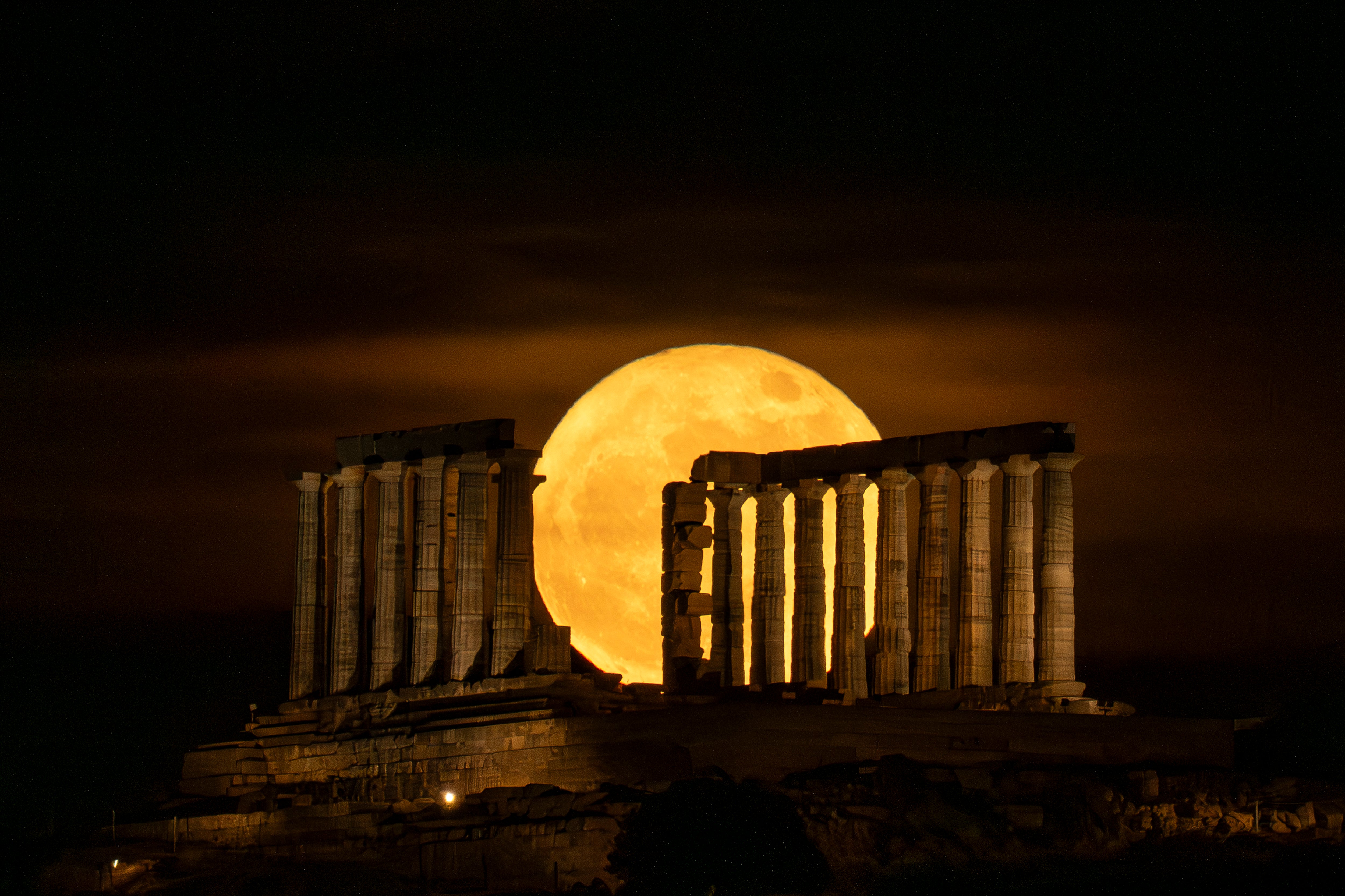 The full Moon rises behind the Greek ancient Temple of Poseidon at cape Sounion, south of Athens, on 31 May, 2026