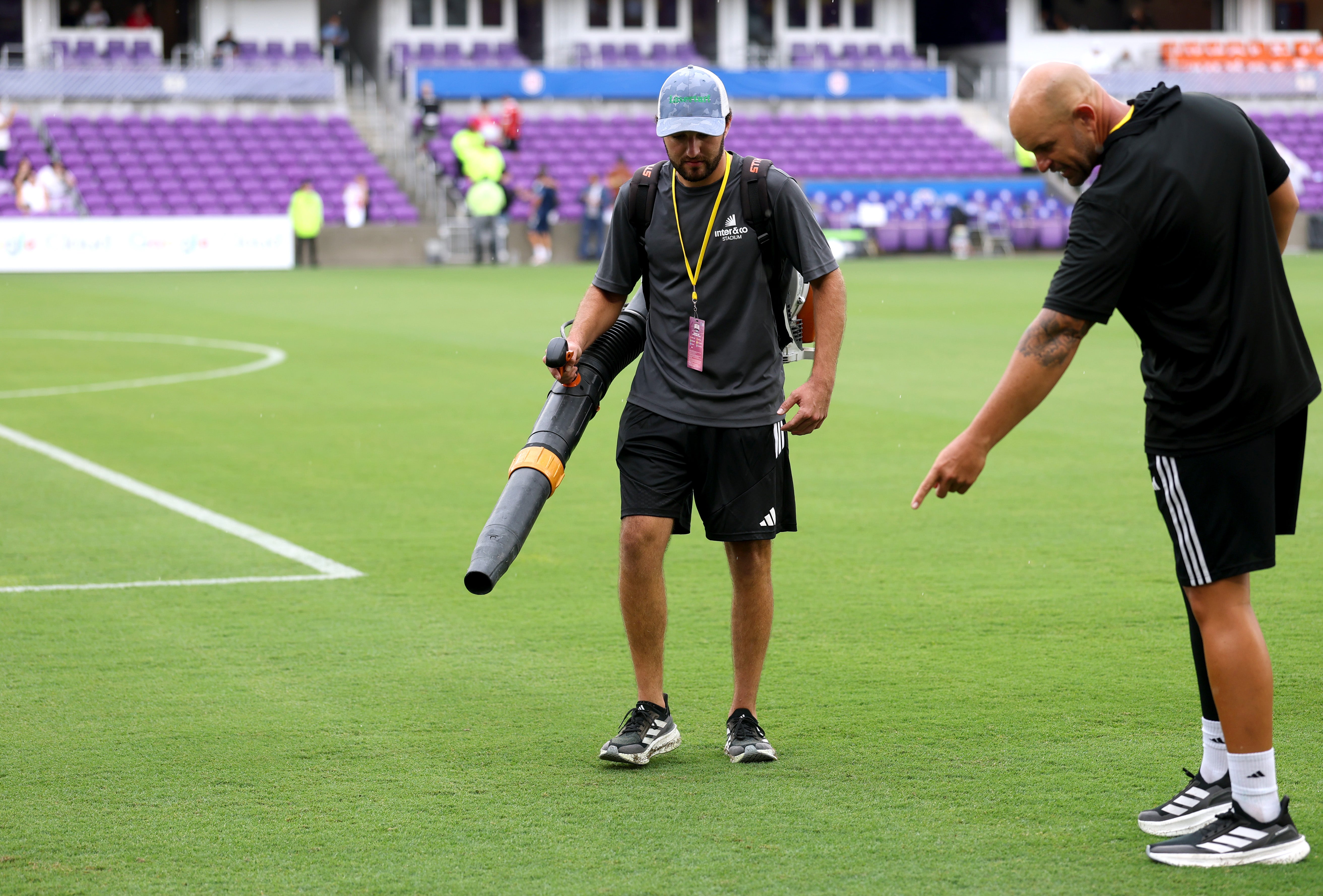 A member of ground staff dries the pitch following heavy rain prior to the International Friendly match between England and Costa Rica