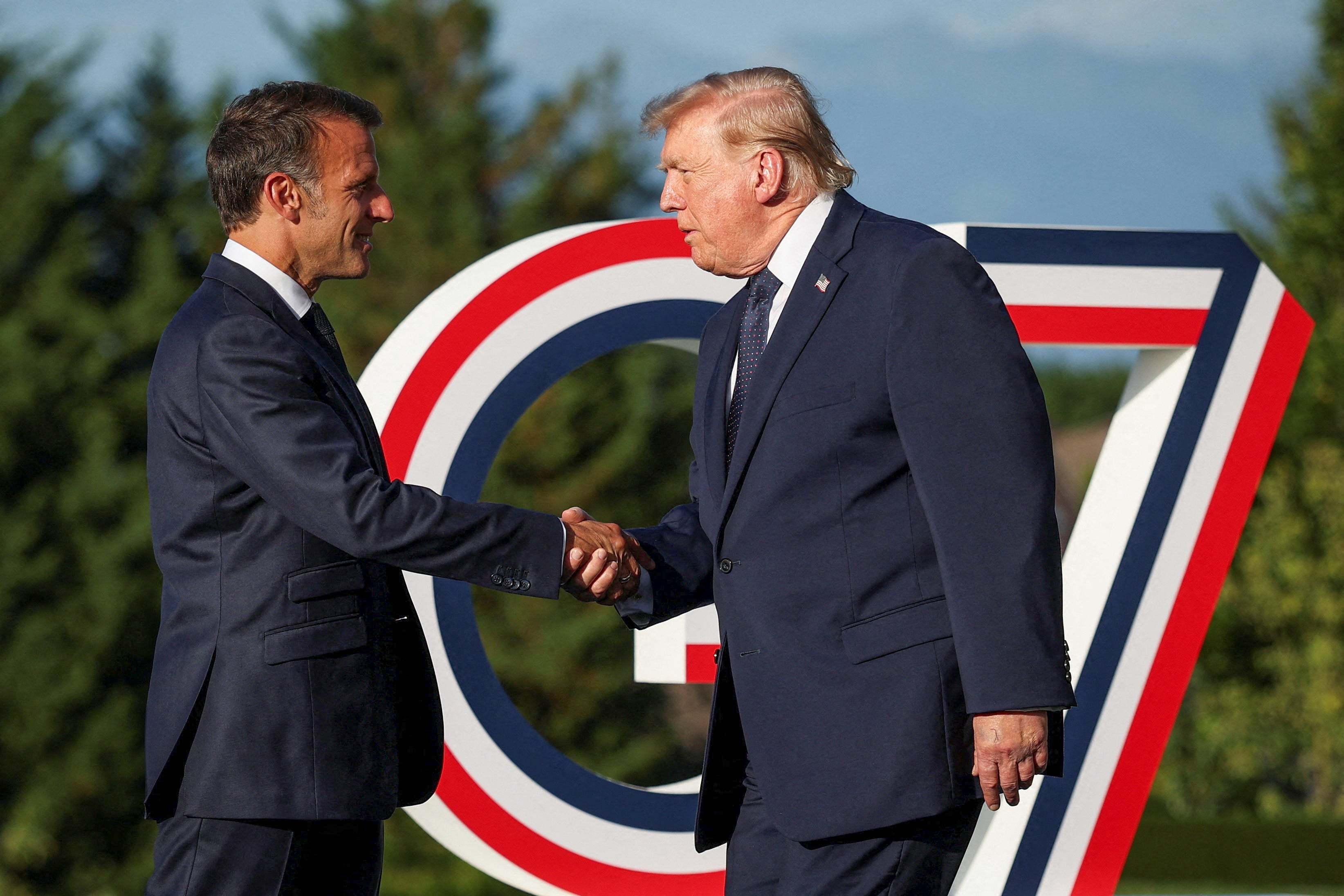 Emmanuel Macron (L) greets US President Donald Trump during the G7 summit, in Evian, central-eastern France, on June 15