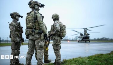 British special forces on a runway with a helicopter nearby