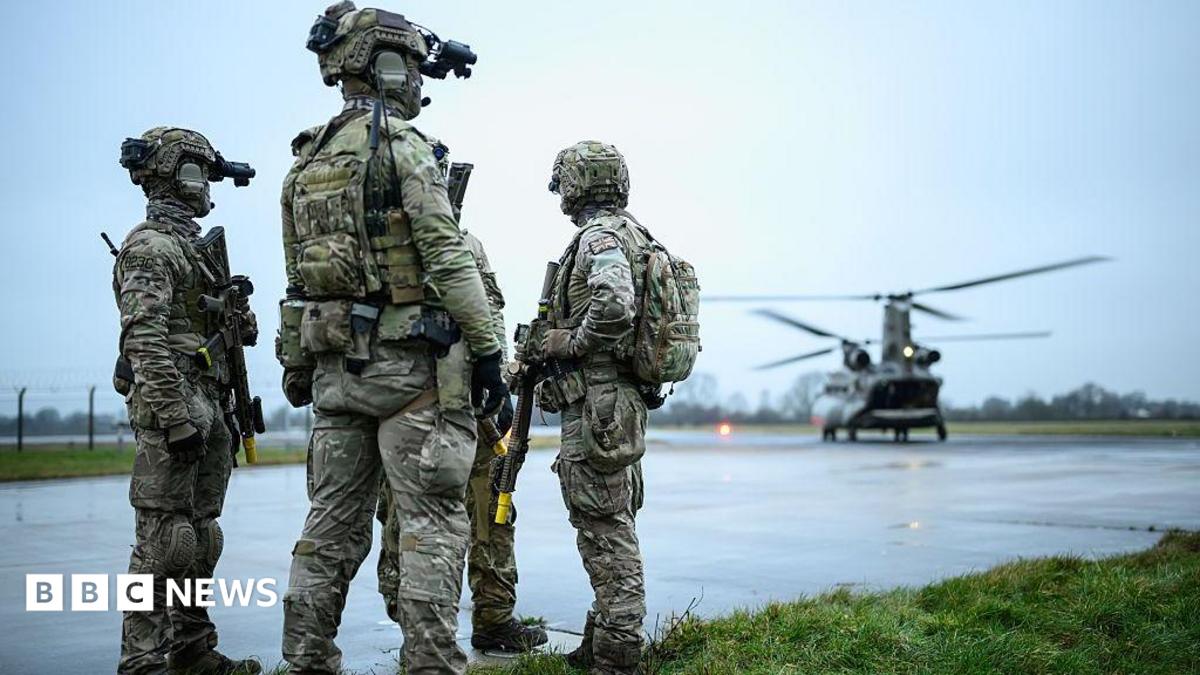 British special forces on a runway with a helicopter nearby