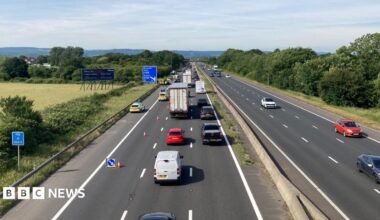 Traffic is building on a motorway where one lane is closed near an incident on the hard shoulder.