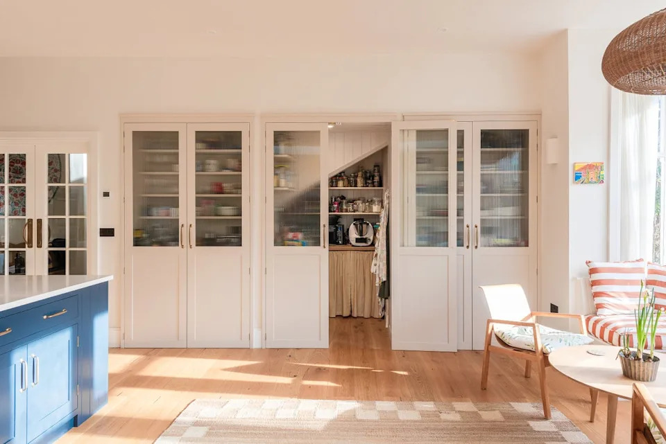 A walk-in pantry and breakfast station sit neatly behind a wall of cabinetry, showing how smart storage can help every inch of a kitchen work harder (Herringbone Kitchens/PA)